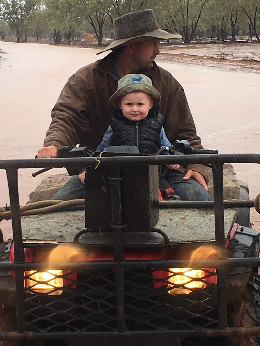 A little boy and his dad on a property in the rain