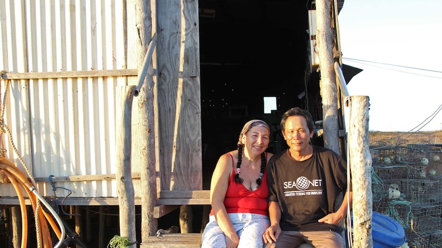 two people sitting on the steps of a tin shed