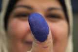 An Egyptian woman shows her ink-stained thumb after voting at a polling station in the Manial neighbourhood of Cairo.