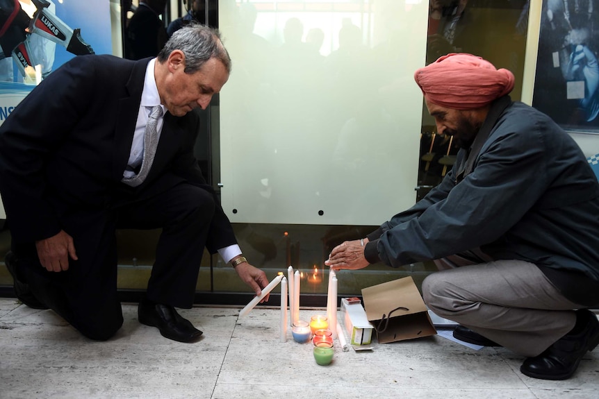 Members of the local community light candles for shooting victim Curtis Cheng