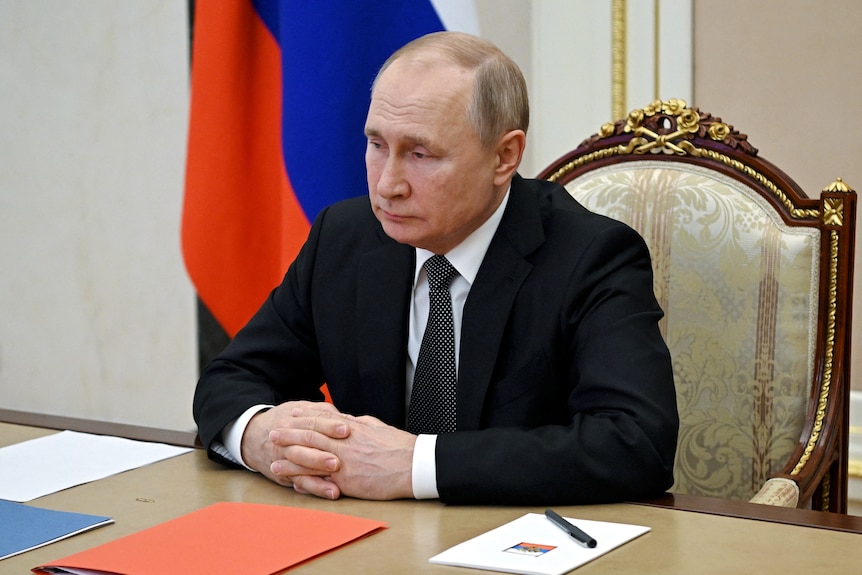 Close up of seated Russian President Vladimir Putin.