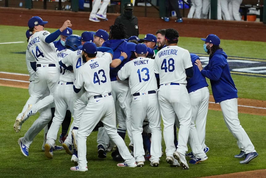 A group of Los Angeles Dodgers Major League Baseball players embrace as they celebrate winning the World Series.