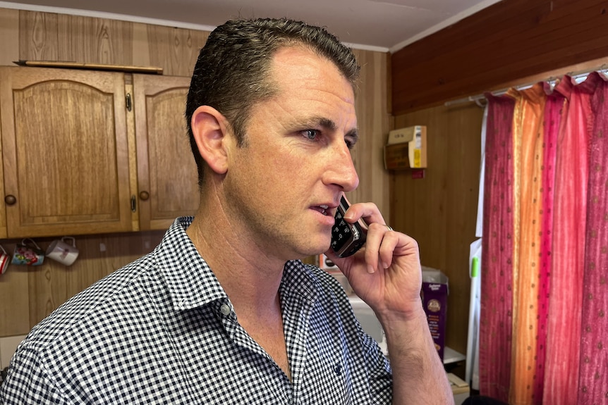 Man holds phone to his ear.