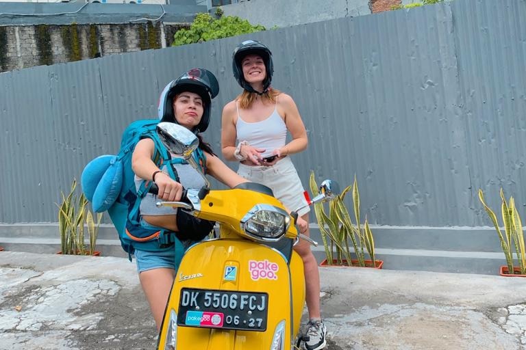 Two women wearing helmets on a rented scooter in Bali.