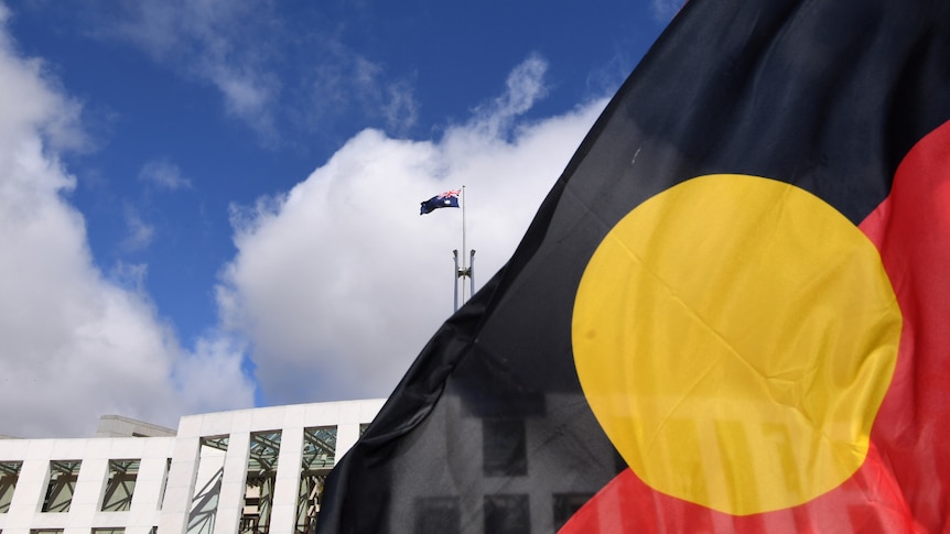 An Aboriginal flag in the foreground, Parliament House in the background