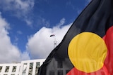 An Aboriginal flag in the foreground, Parliament House in the background
