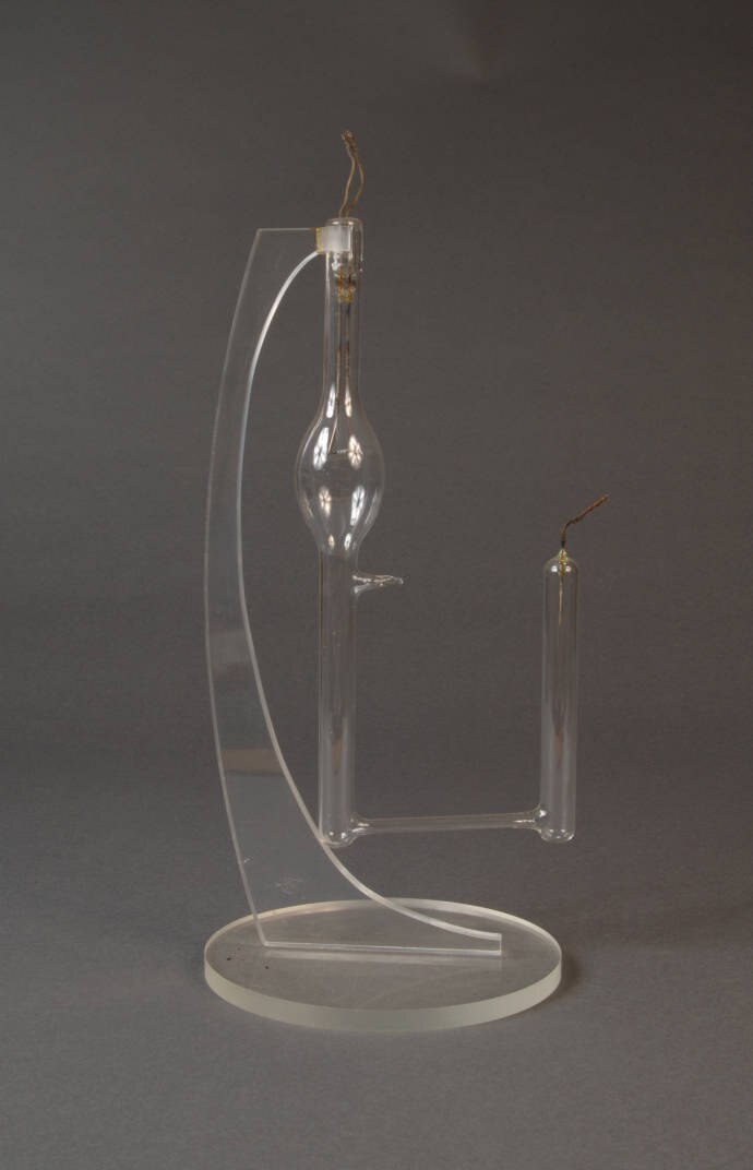 A glass lamp filled with colourless gas.