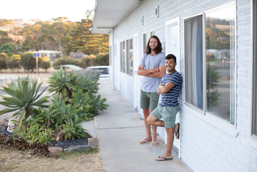 Two men standing outside a motel