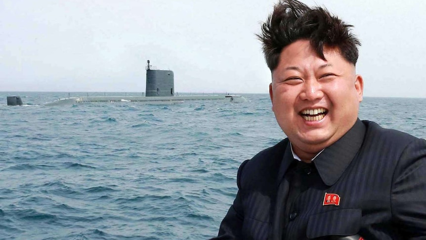 North Korean leader Kim Jong-Un laughs while sitting at an undisclosed location at sea.