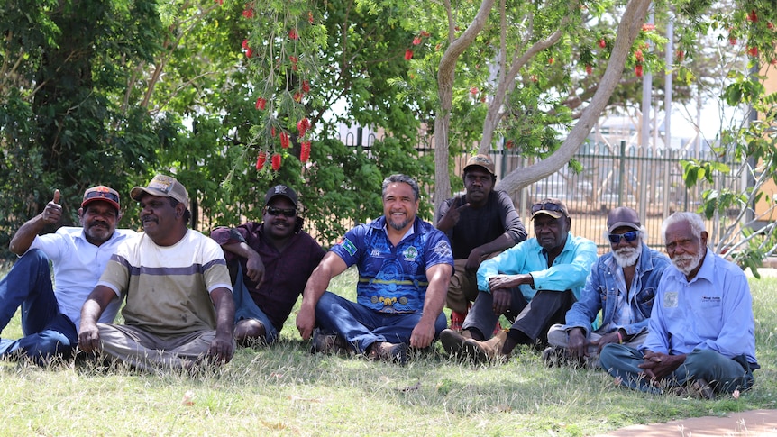 A group of Waanyi men sit on the grass