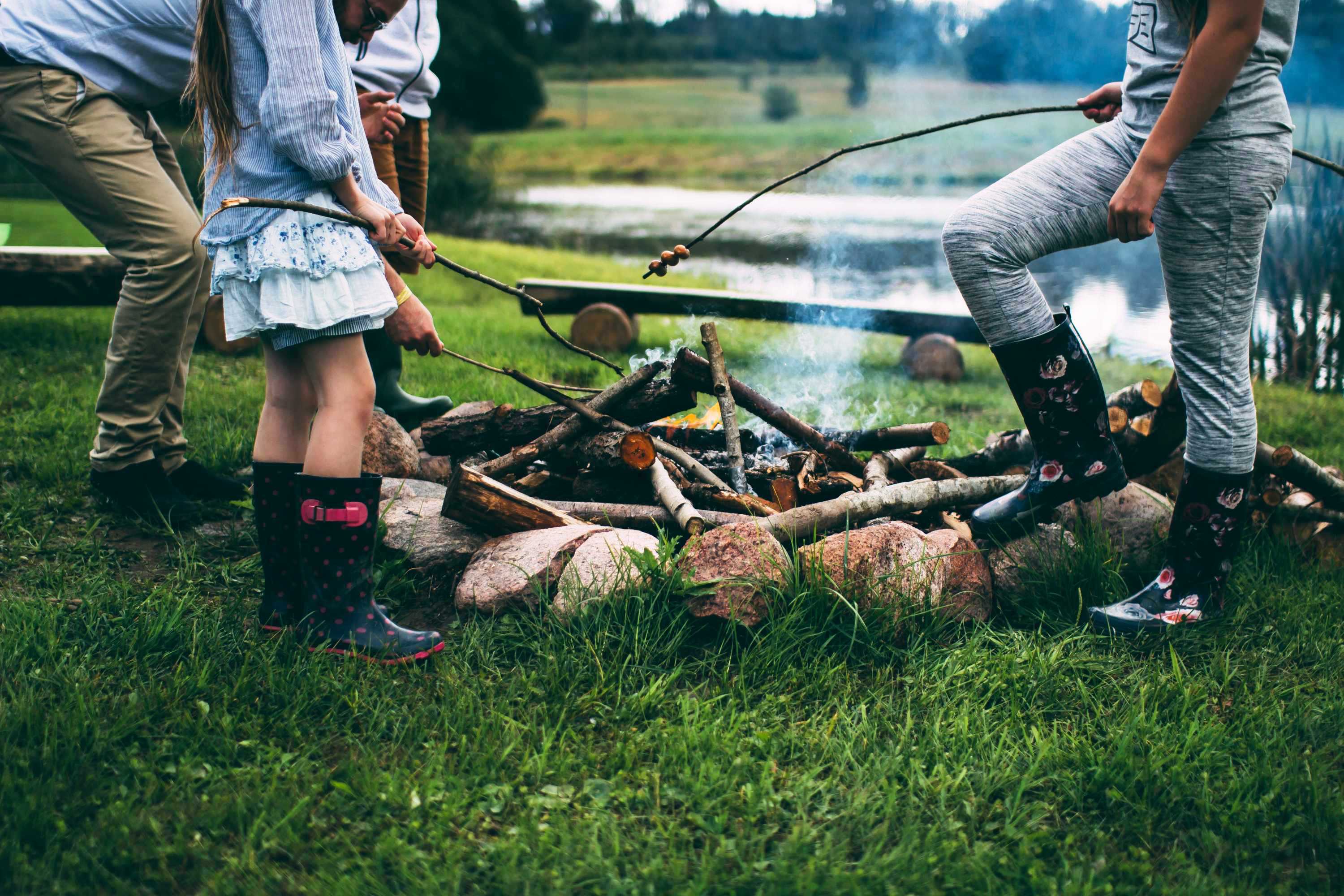Family toasts marshmallows around a campfire for a story about surviving school holidays as a family.