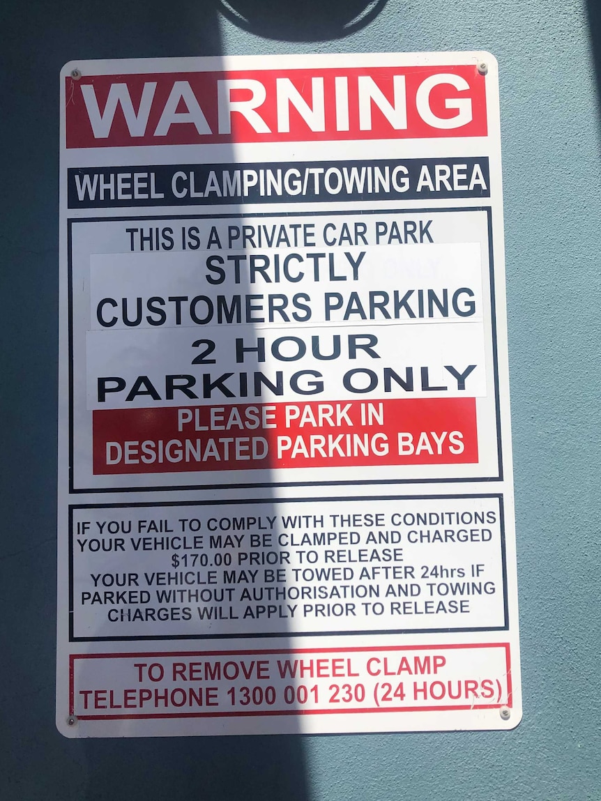 A photo of a sign warning of wheel clamping in the area.