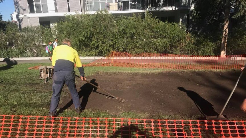 Council workers smooth-out dirt where concrete slab used to be