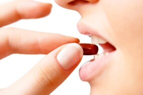 Woman putting medicine in mouth (Thinkstock: Getty Images)
