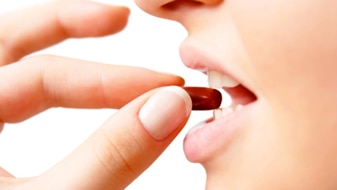 Woman putting medicine in mouth (Thinkstock: Getty Images)
