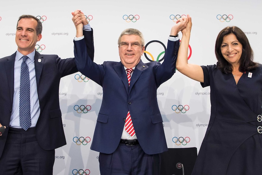 The Mayor of LA, Eric Garcetti, IOC president Thomas Bach and the mayor of Paris, Anne Hidalgo on stage in Lausanne, Switzerland