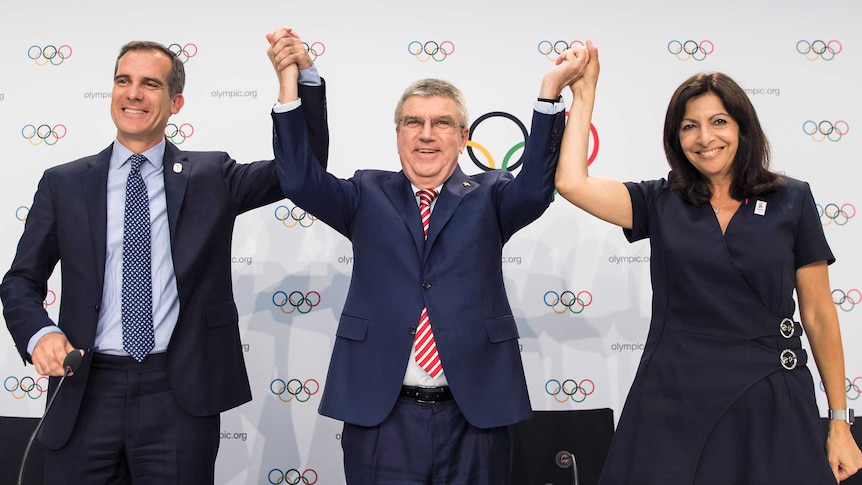 The Mayor of LA, Eric Garcetti, IOC president Thomas Bach and the mayor of Paris, Anne Hidalgo on stage in Lausanne, Switzerland
