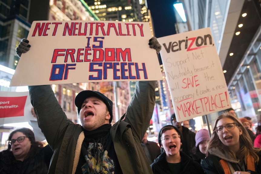 A demonstrator holds up a sign protesting planned changes to net-neutrality laws.