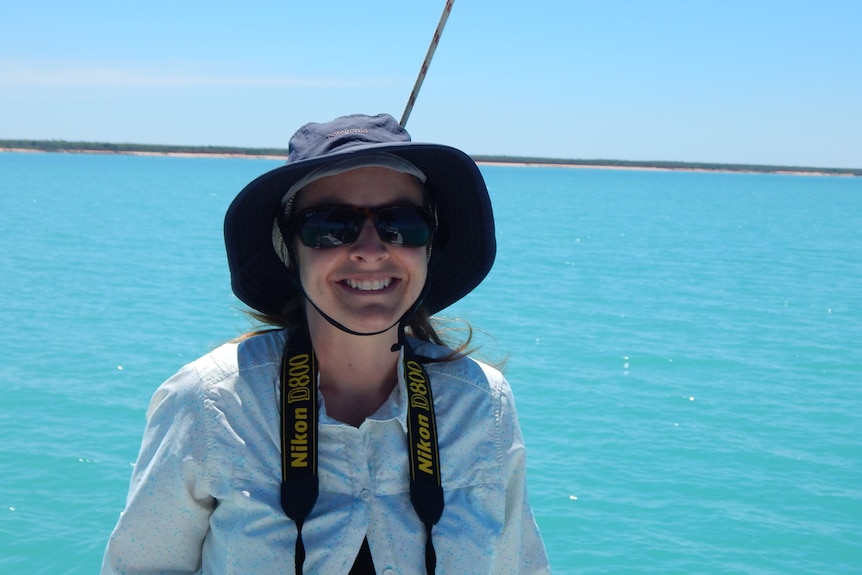 Holly Raudino on a boat with a camera around her neck.