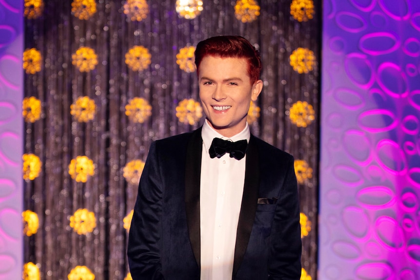 Comedian Rhys Nicholson standing on the runway of RuPaul’s Drag Race Down Under