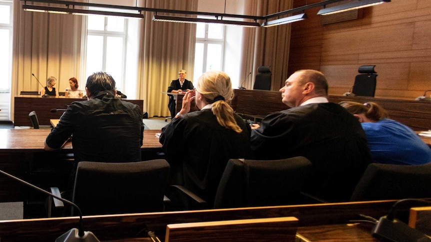Photographers take pictures of the man and a woman in the court in Freiburg, southern Germany.