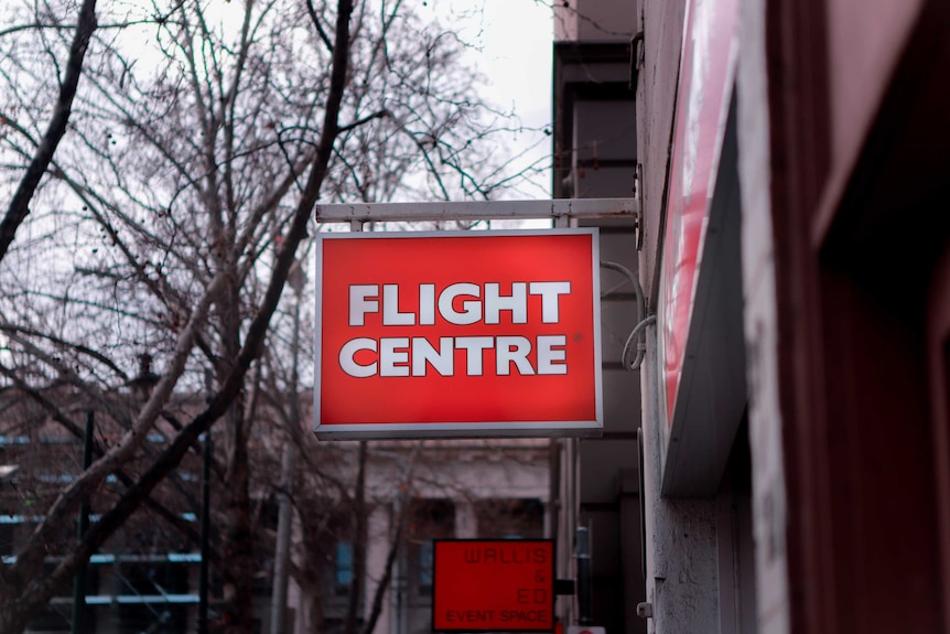 A red Flight Centre sign in a street.