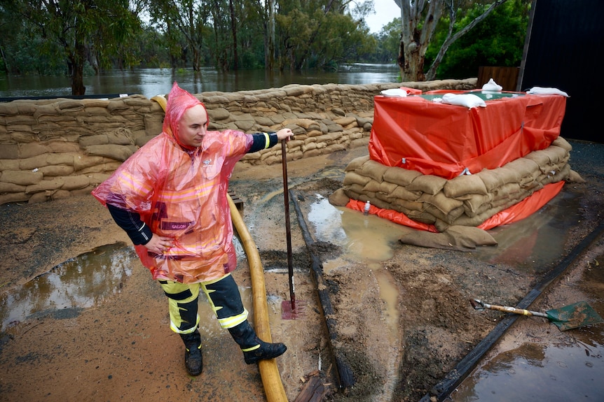 An emergency worker inspects a levee holding back flood waters