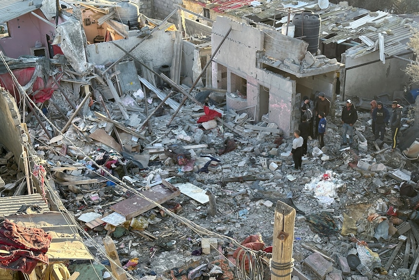An aerial view of a large pile of rubble and household items where a house used to be.