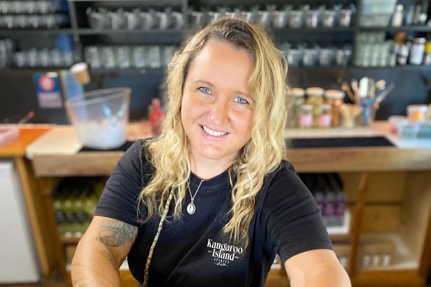 woman wearing black t-shirt holds drink smiling 