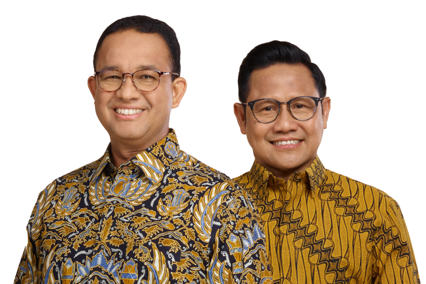 Two middle-aged men, wearing batik shirts, both wearing glasses smile at the camera.