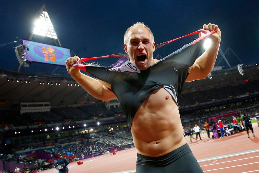 Germany's Robert Harting rips his shirt off as he celebrates winning gold in the discus.
