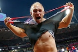 Germany's Robert Harting rips his shirt off as he celebrates winning gold in the discus.
