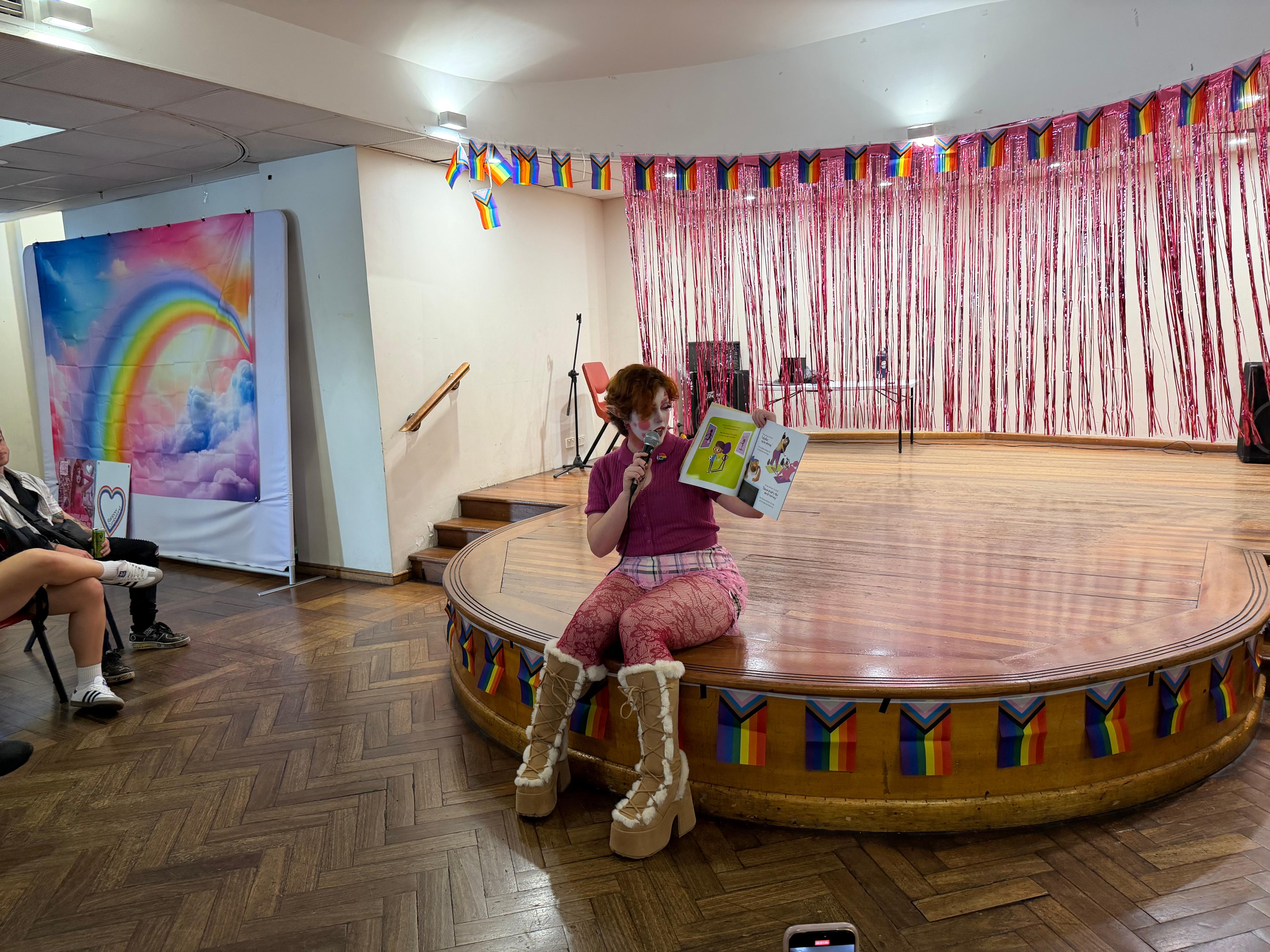 Lavish Lazuli lê um livro sentado no palco