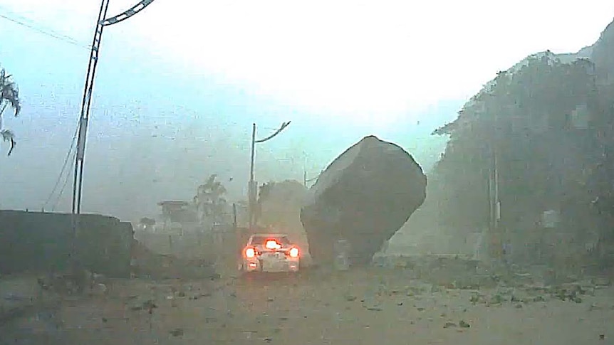 A car has narrowly escaped being crushed beneath a massive boulder.