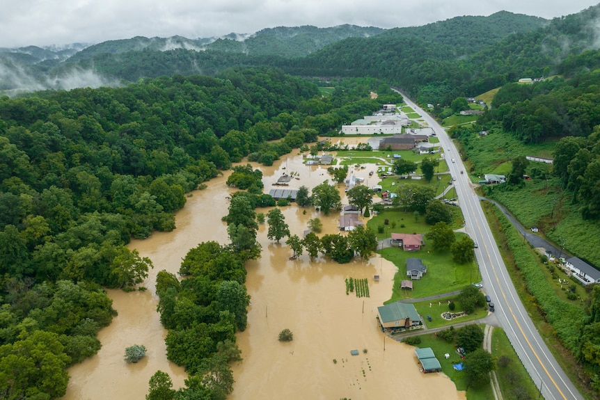 An aerial view of what used to be a picturesque town in rural Kentucky now half submerged by brown water.