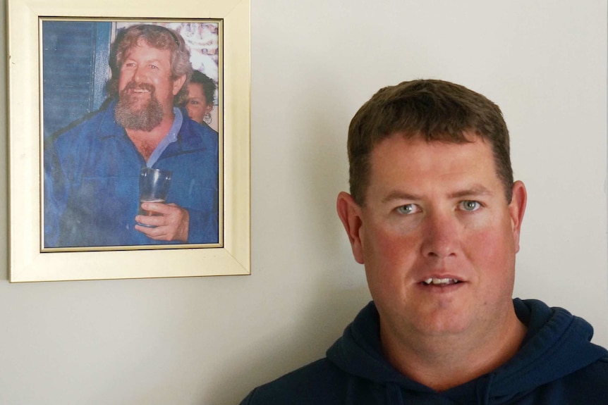 Craig Swindle with a photo of his late father Kevin Swindle, who died of cancer in 2012.