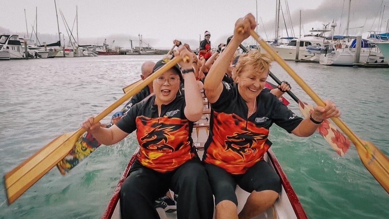 Jennifer Wong and the Hervey Bay Dragons paddling in a dragon boat.