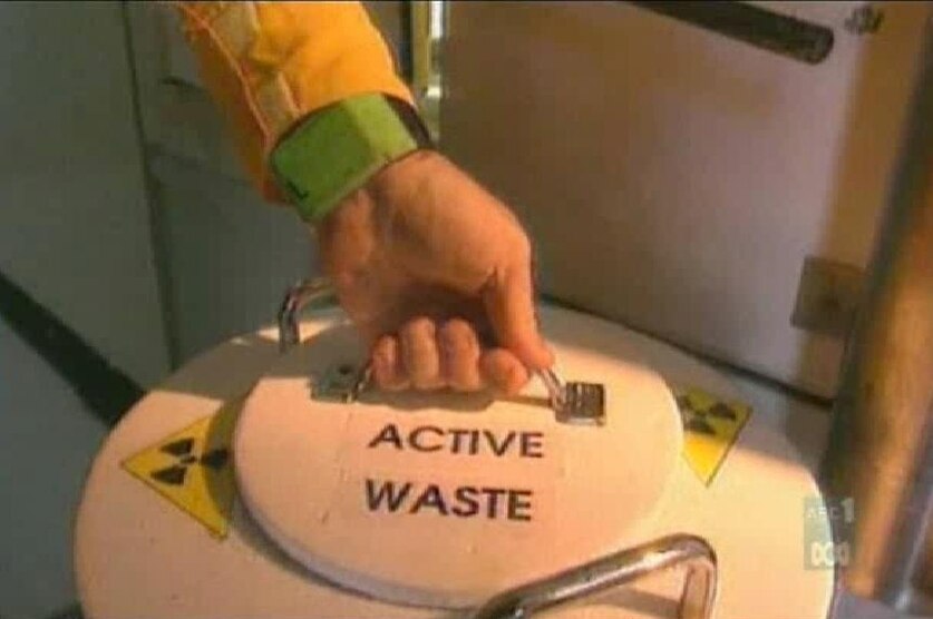 Good generic TV still of hand on handle of nuclear waste cannister (ABC)