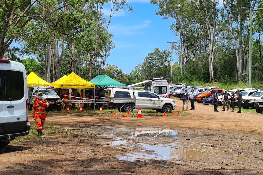 Bushland with police and SES cars.