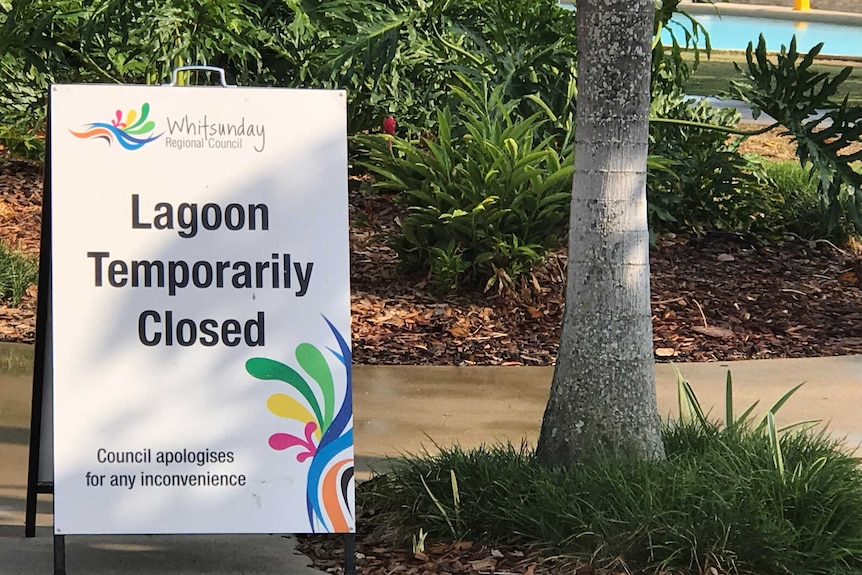A "Temporarily Closed" sign at a man-made lagoon in tropical Queensland.