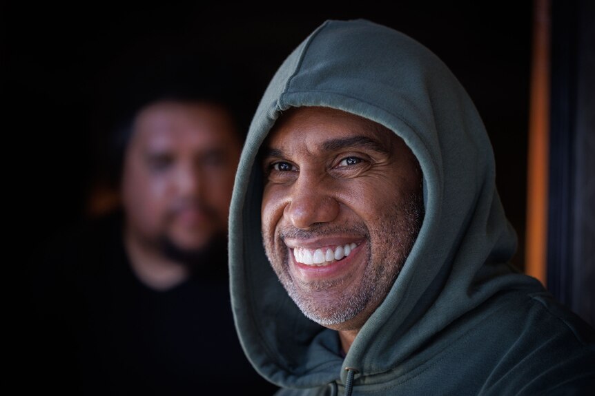 Close up of man in hoodie smiling.