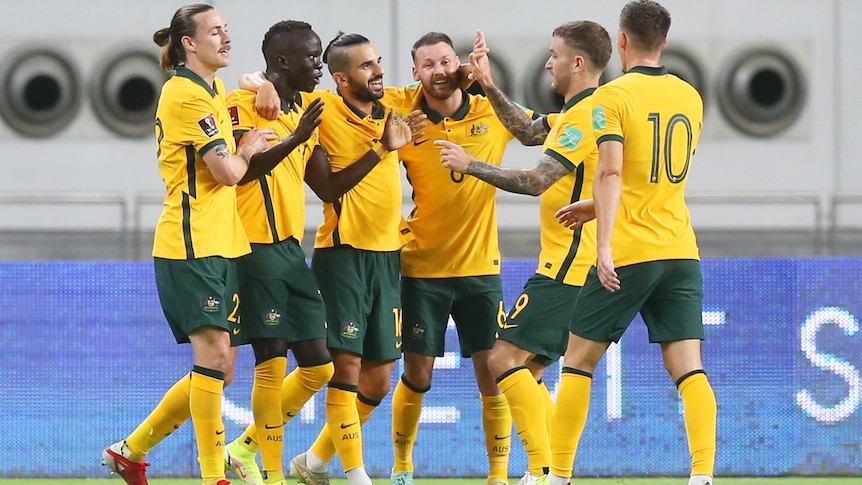 Socceroos celebrate by hugging each other