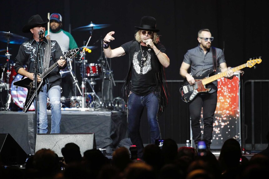 Big & Rich perform on a dark stage