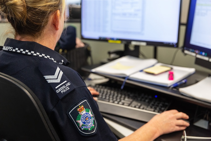 A female police officer working at a computer