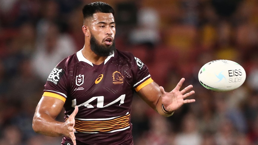 A Brisbane Broncos NRL player prepares to catch a pass against the Sydney Roosters.