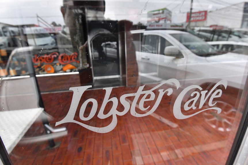The logo for Lobster Cave is etched into a glass panel outside the restaurant in Melbourne.