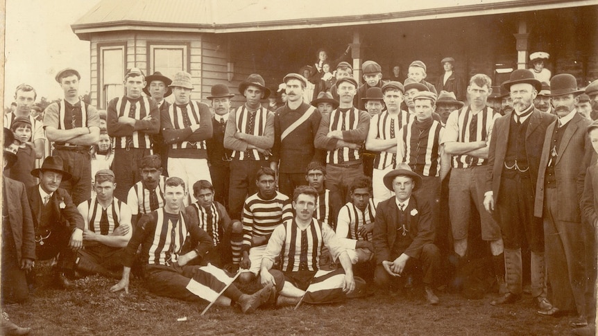 Football players pose for a team photograph, 1908.