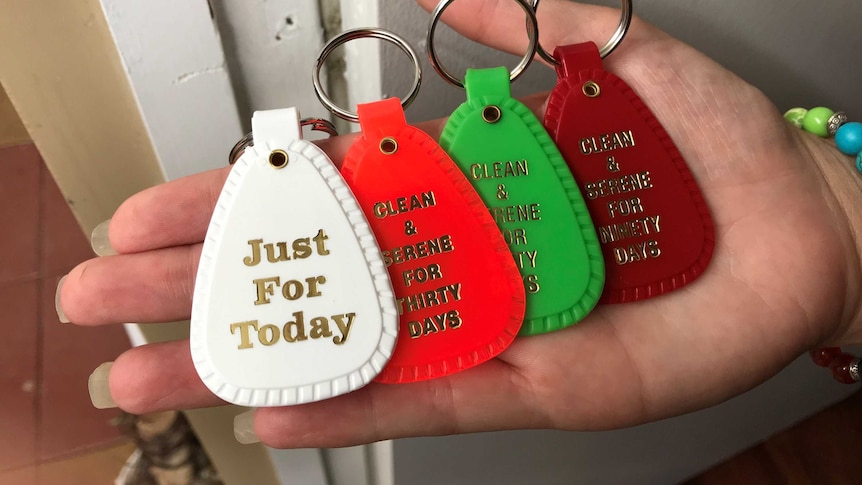 A woman's hand holds four key-rings with 'clean and serene for 30 days' written on each