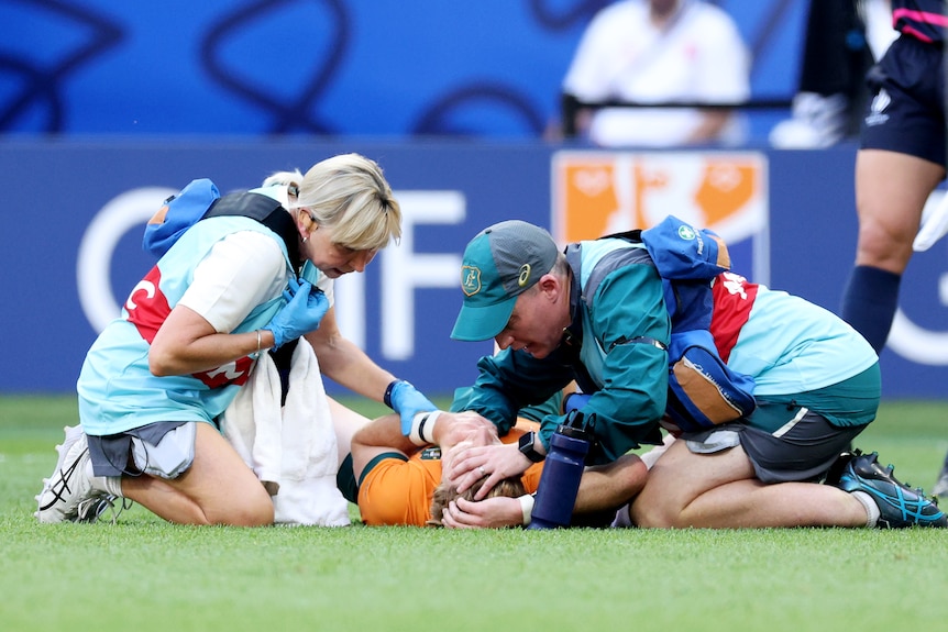 Tate McDermott of Australia receives medical attention during 2023 Rugby World Cup opener.