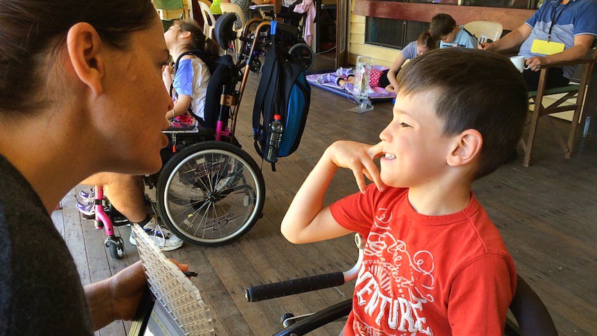 Finley speaks with his mum using an electronic device.